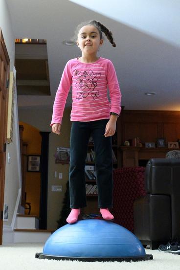 Six-year-old Kailei Prevost burns off some of her energy in her family’s living room.