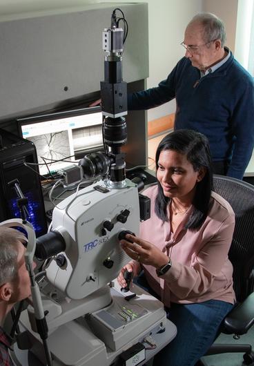 Swati More, Ph.D., and Robert Vince, Ph.D., assess a patient using the noninvasive retina scan technology they developed.